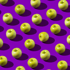 Colorful Fresh Green Apple Pattern on purple or violet background. Minimal fruit concept. Flat lay food texture. Top view. Summer abstract trendy concept. Hard light.