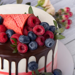 Cake with berries on a light wood background
