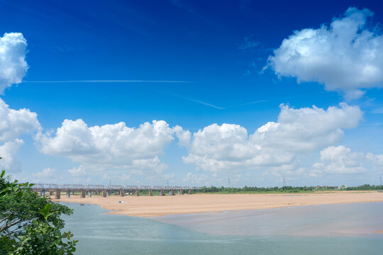 Beautiful landscape sccenic image of Mahanadi river of Odisha, with blue sky and white clouds in the background. Nature stock image of Odisha with copy space.