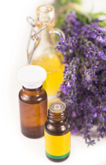 Fresh lavender bottles of aromatic oil on a white background. Summer floral background with lavender flowers