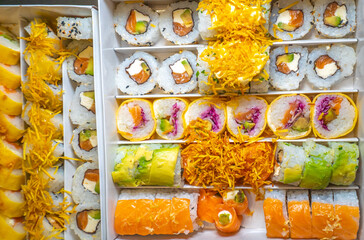Large sushi set on black. An assortment of various maki, nigiri and rolls. Close up.
