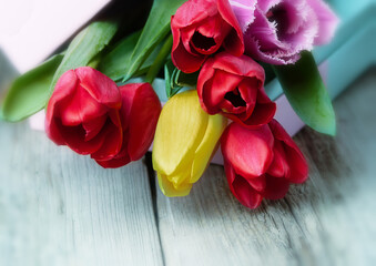 Fototapeta premium gift box with bouquet of tulips on wooden background closeup