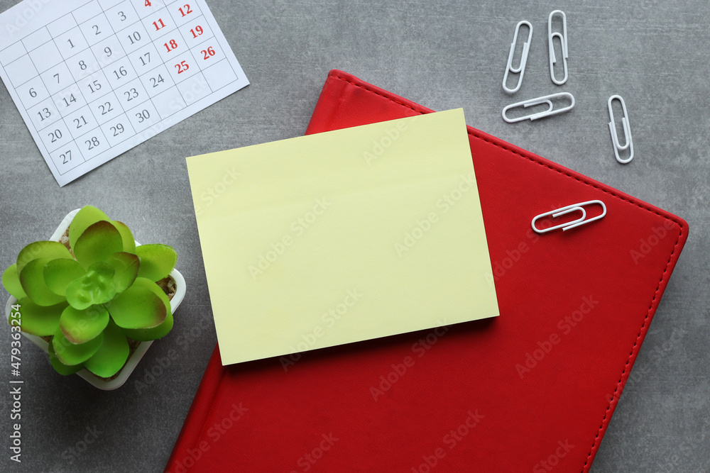 Poster blank notepad on red notepad with pen on wooden background business concept. top view with copy spac