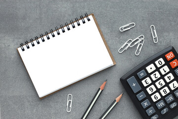 Calculator and brown open notepad with blank notepad. Flat lay business concept.