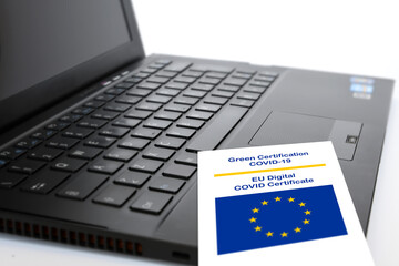 Close-up of the Green Certificate Covid-19 of the European Union paper on the keyboard of a...