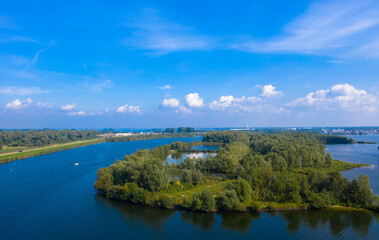 Obraz premium Aerial view of the Wolderwijk lake with small green islands that offer shelter to various species of fish and birds. Dutch province of Flevoland, Netherlands.