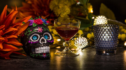 Day of the dead skull with red wine, flowers and lights