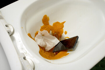 close-up view of smartphone falling in the toilet 