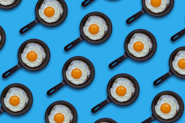 Cast iron frying pan with a fried egg on a blue background. Seamless pattern