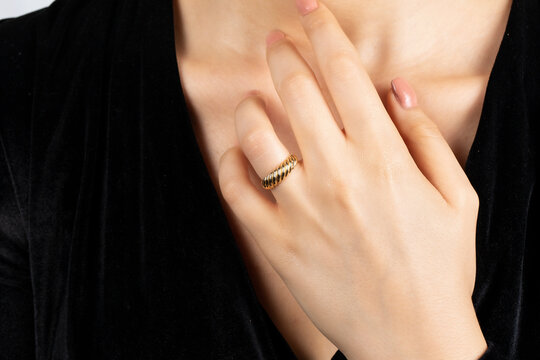Close portrait of female model in gold and silver rings. Isolated on white background . Diamond jewelry. Diamond ring in women's hands