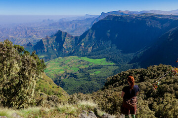 Fototapeta na wymiar White Woman Tourist looking at the Green Valley of Simien Mountains near Gondar, Northern Ethiopia