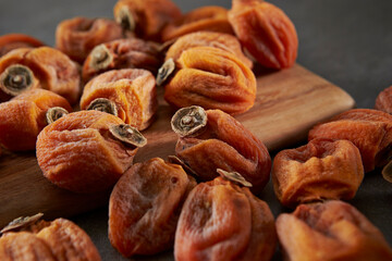 Dried persimmons on a wooden chopping board	