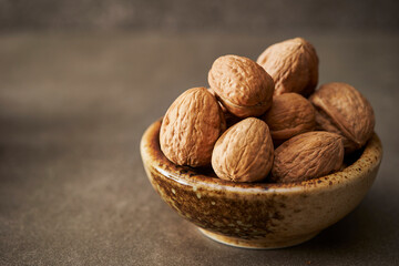 Walnuts in a bowl on a dark background