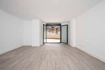 Room with freshly painted white walls with ceramic floors, front door and large window that opens to a patio.
