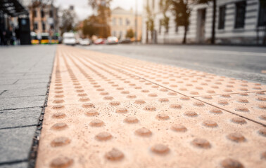 Yellow Braille blocks on public transport station for person with a physical disability