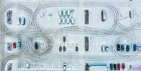 Aerial top view parked snow covered cars. Many snowy cars on the parking at the winter snowfall