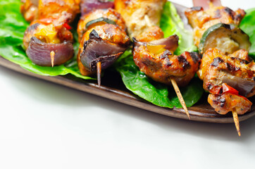 Grilled skewers with chicken, zucchini, mushrooms, peppers and onions served on iceberg lettuce