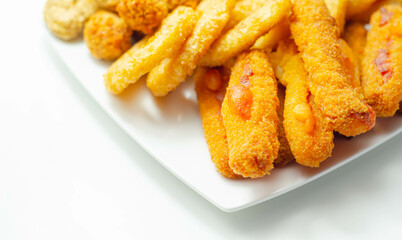 Southern fried and roast chicken bites, onion rings and mozzarella stick served on the white plate