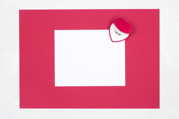 Blank white paper with red frame and velvet heart shaped gift box with wedding ring inside. Copy...