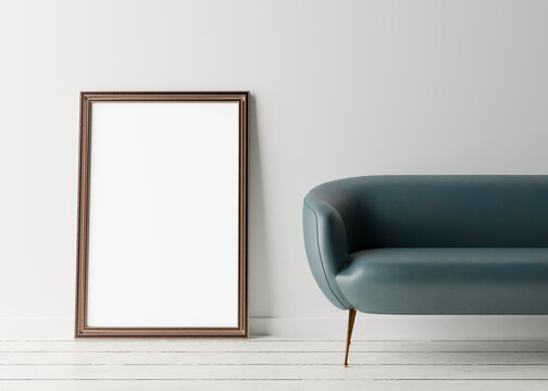 Empty vertical picture frame standing on the floor, with white wall and blue leather couch. Mock up interior in minimalist style. Free space, copy space for your picture or text. 3D rendering.