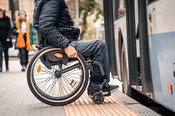 Person with a physical disability enters public transport with an accessible ramp.