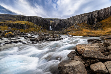 Folaldafoss waterfall and glacial river, Berufjordur, East Fjords, Iceland. Long exposure shot of fast flowing water, autumn.