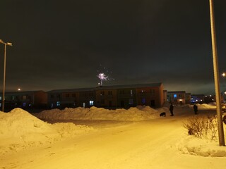 New Year's fireworks in the cottage village on a winter night