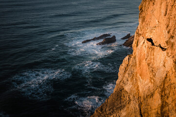 Rocks and ocean surf near the Portuguese lighthouse Cabo da Roca, Sintra, Portugal.