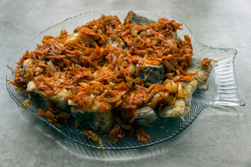 Fried fish with vegetable side dish on a glass dish