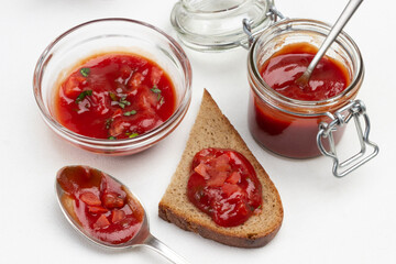 Tomato sauce in spoon and on piece of bread.