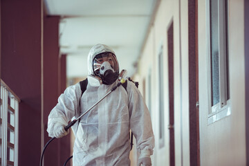 Medical staff wearing PPE spraying disinfectant against the spread of the virus