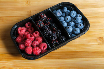Prepacked selection of Raspberries, Blackberries and Blueberries in plastic tray from supermarket