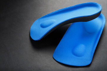 Orthopedic insoles for correction of pronation of the foot on a dark background.