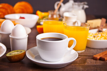 Cup of coffee, juice, eggs, fruits, toasts. Breakfast concept.
