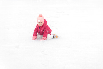 Fototapeta na wymiar adorable little girl ice skating on the ice rink