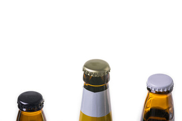 Close up view of three different  beer bottles with metal caps isolated on white background.