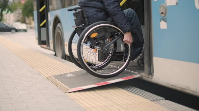 Person with a physical disability enters public transport with an accessible ramp