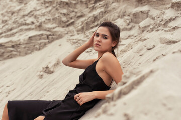 Fototapeta na wymiar Tanned brunette in the sand dunes
