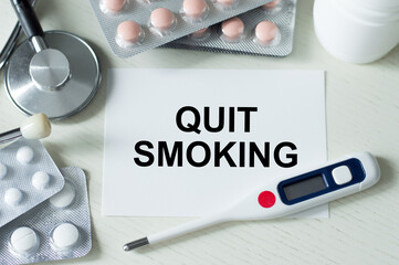 On the business card, the text of quit SMOKING, next to the capsules, thermometer and stethoscope