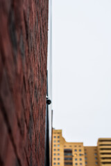 Building element. Modern architecture. Design project. Uneven surface. Steel construction. Brickwork. New building. Surveillance Camera. Focus on the wall. Close-up view from the surface of the wall.