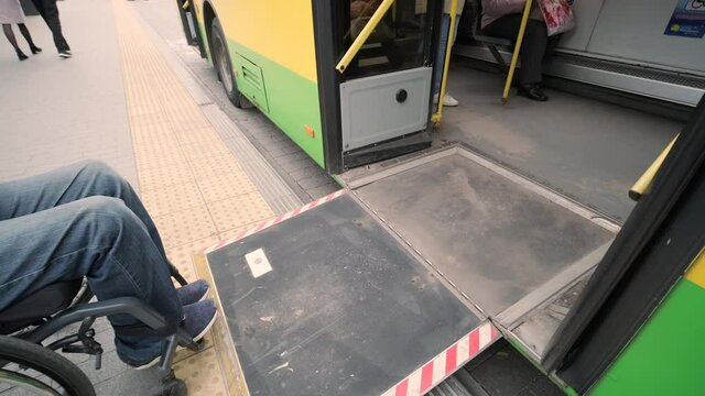 Person with a physical disability enters public transport with an accessible ramp