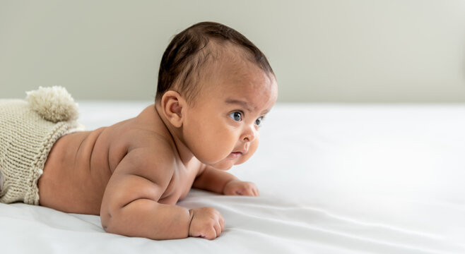 Portrait images of African baby newborn girl is 3 month year old, Lying on white bed in bedroom, to African newborn concept.