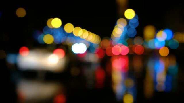 Des lumi&egrave;res floues d'&eacute;clairage de ville la nuit sur une route avec des voitures