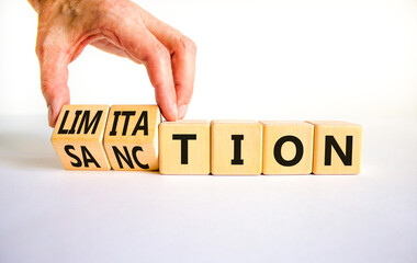 Sanction and limitation symbol. Businessman turns cubes, changes the word limitation to sanction....