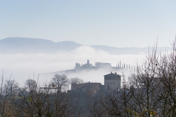 View of the Val d'Orcia in Tuscany immersed in the fog