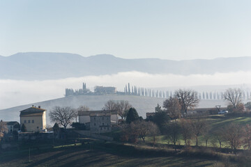 Fototapeta na wymiar View of the Val d'Orcia in Tuscany immersed in the fog