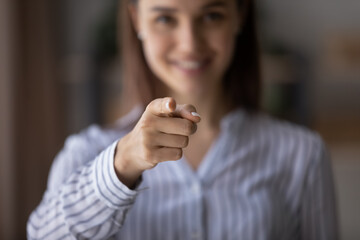 Happy blurred young woman pointing index finger at camera, smiling. Businesswoman, employer, HR...