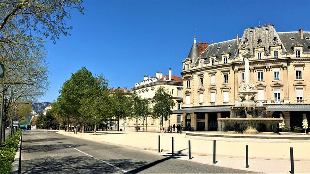 Valence Dr&ocirc;me France Boulevard avec de beaux immeubles haussmanniens et sa fontaine monumentale sur un ciel bleu ensoleill&eacute;.
