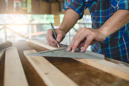 Hands of person doing diy project at home. Man measuring wood to doing cabinet craftworks as a hobby.