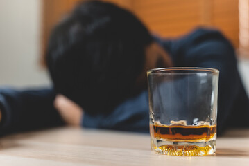 drunk man fall asleep on the table with whiskey glass